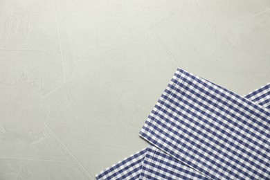 Photo of Blue checkered tablecloth on gray textured background, top view. Space for text