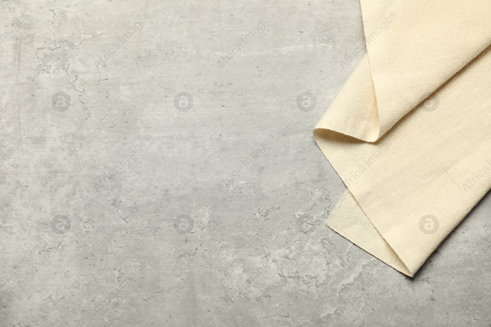 Photo of Beige tablecloth on gray textured background, top view. Space for text