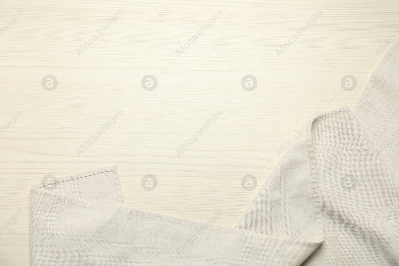 Photo of White tablecloth on wooden background, top view. Space for text