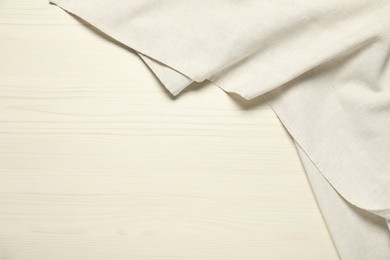 Photo of White tablecloth on wooden background, top view. Space for text