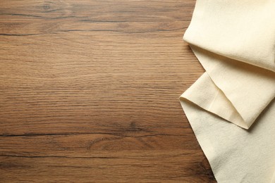 Photo of Beige tablecloth on wooden background, top view. Space for text