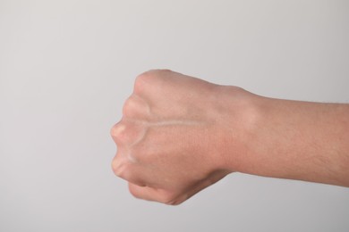 Photo of Woman with visible hand veins on light grey background, closeup