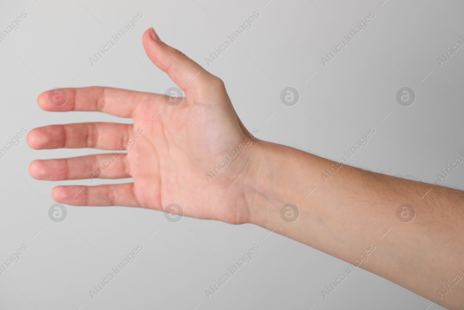 Photo of Woman with visible hand veins on light grey background, closeup