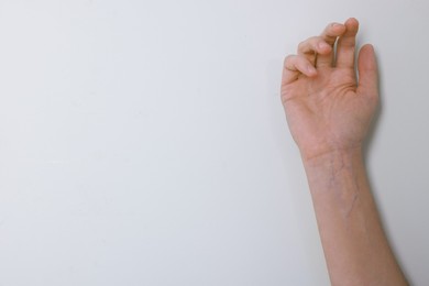 Photo of Woman with visible hand veins on white background, closeup. Space for text