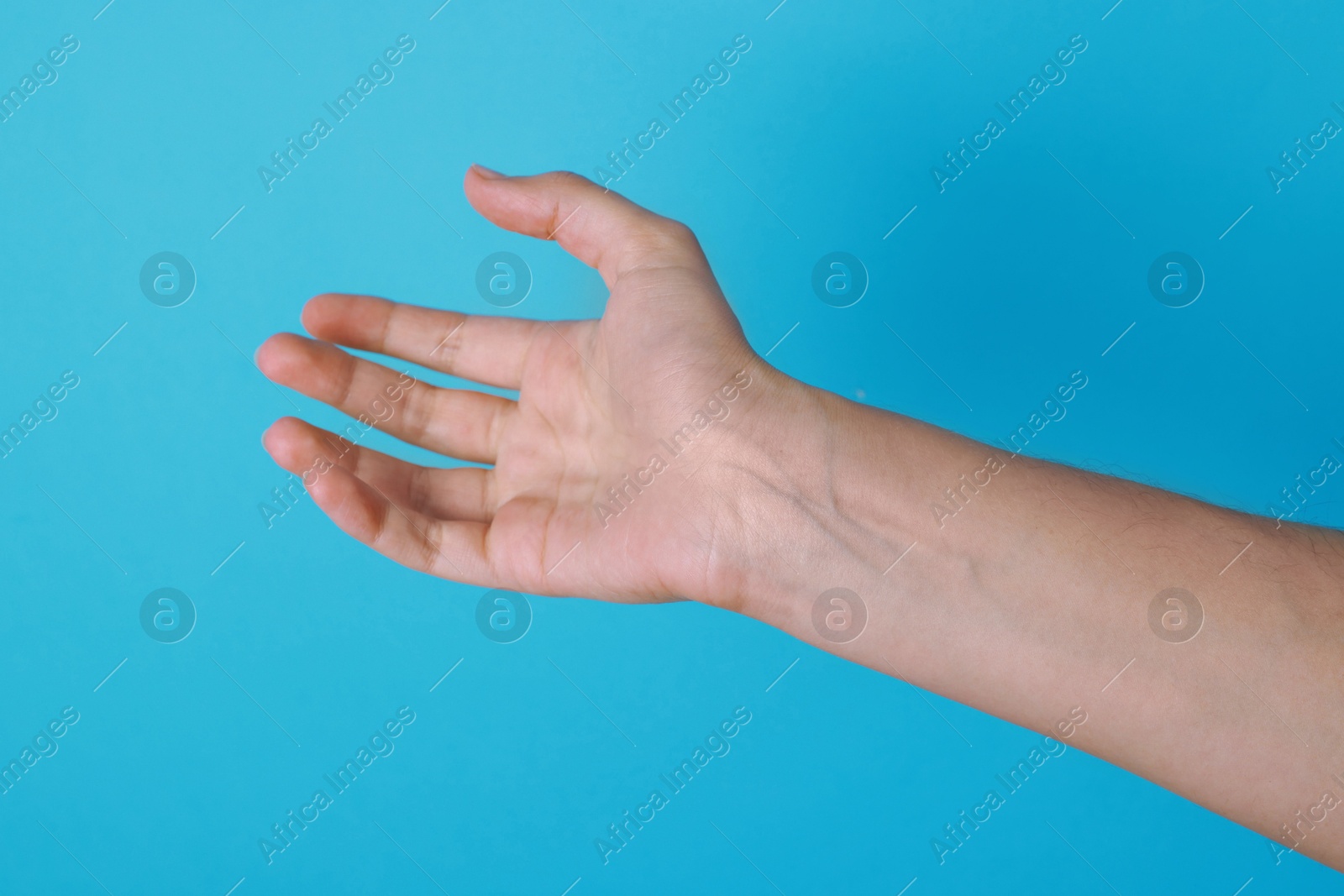 Photo of Woman with visible hand veins on light blue background, closeup