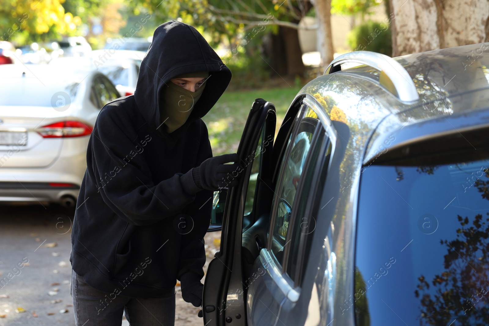 Photo of Thief breaking into modern auto. Car hijacking