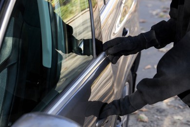 Photo of Thief breaking into auto, closeup. Car hijacking