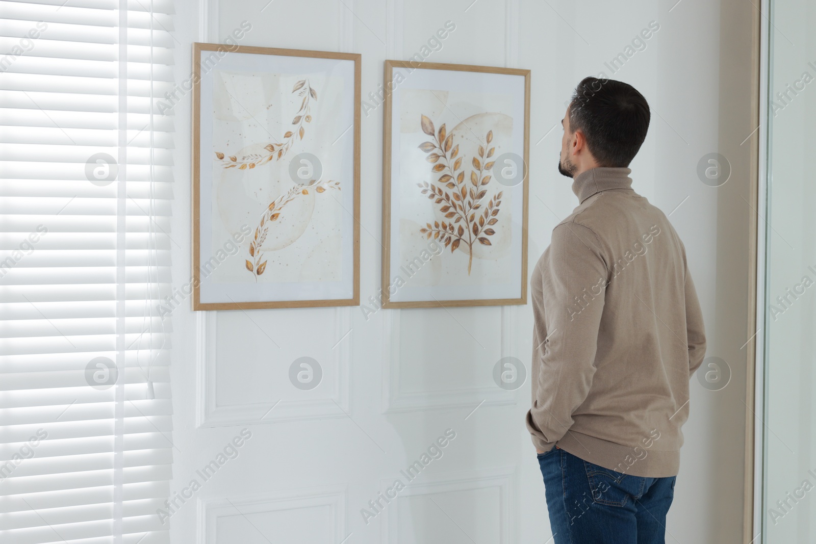 Photo of Man studying beautiful artwork in modern gallery