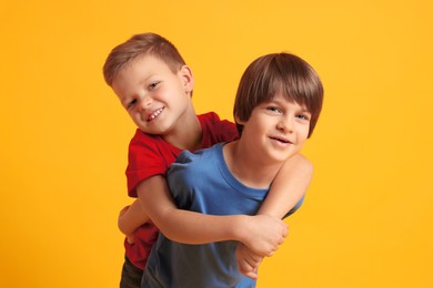 Photo of Portrait of cute brothers on orange background