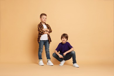 Photo of Full length portrait of cute brothers on beige background