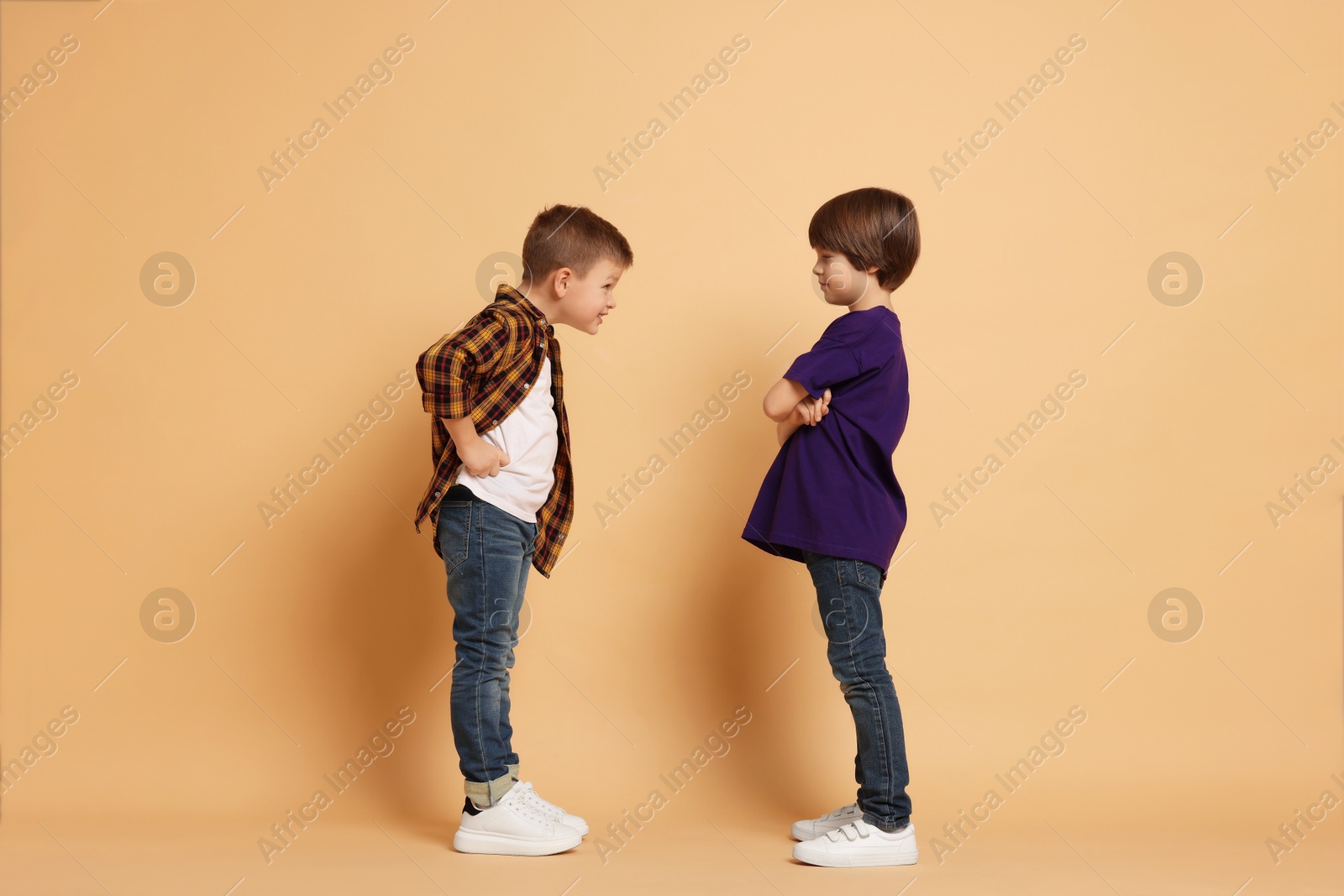 Photo of Angry brothers having argument on beige background