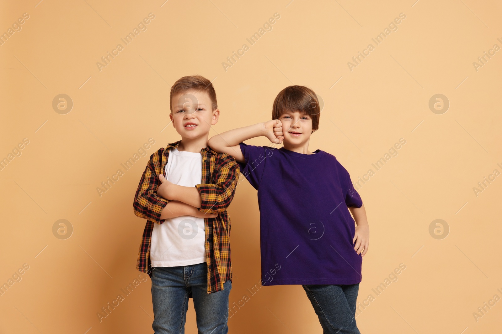 Photo of Portrait of cute brothers on beige background