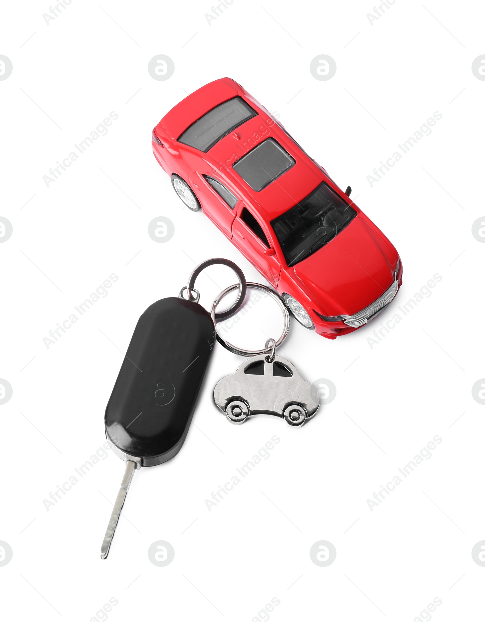 Photo of Car key with keychain and toy isolated on white, top view. Buying auto