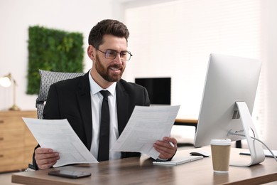 Photo of Man working with documents at table in office