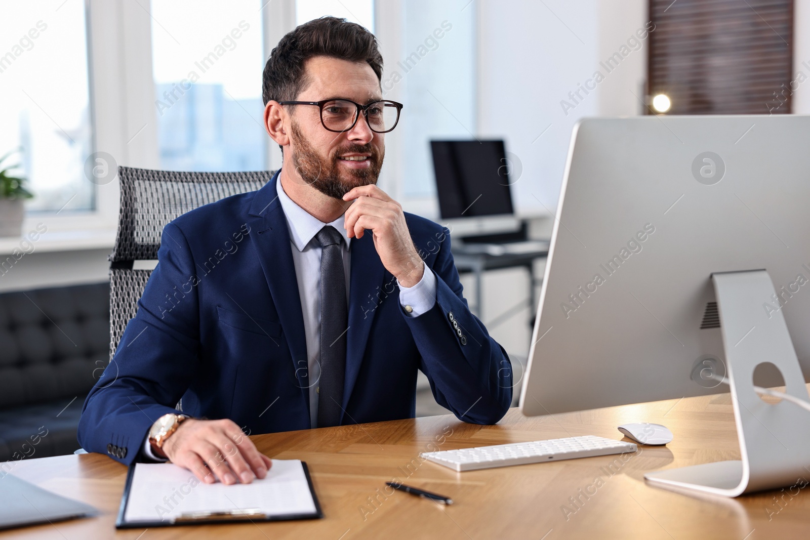 Photo of Man working with computer at table in office