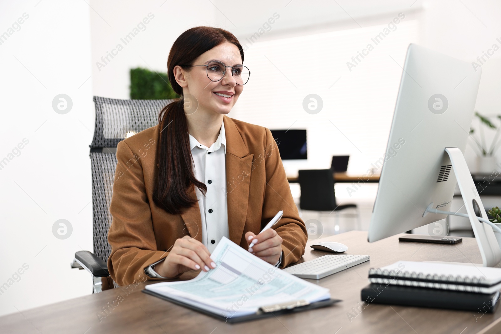 Photo of Woman working with document at table in office