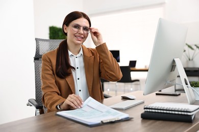 Photo of Woman working with document at table in office