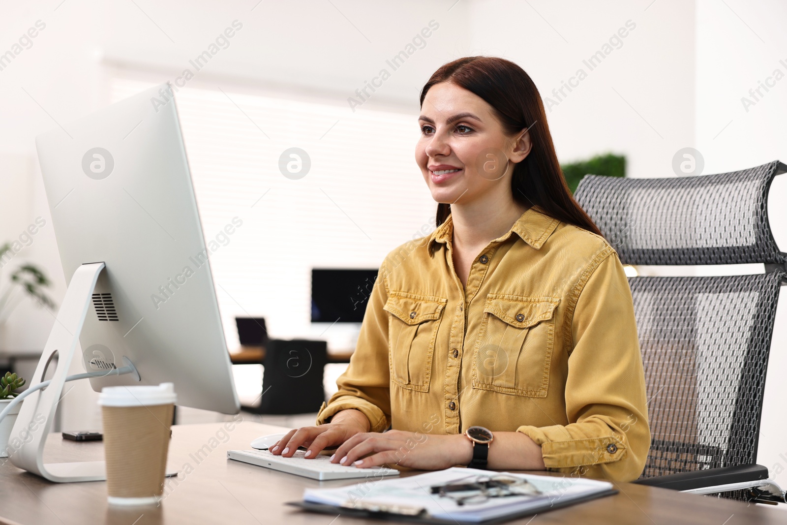 Photo of Woman working on computer at table in office