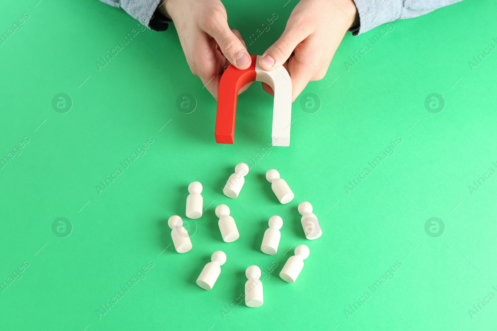 Photo of Man with magnet attracting game pieces at green table, above view