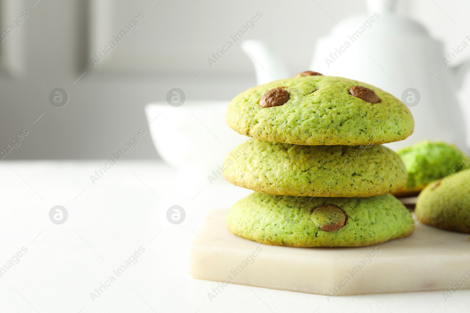 Photo of Delicious mint chocolate chip cookies on white table, closeup. Space for text