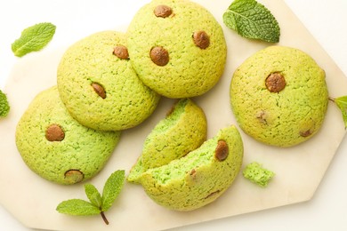 Photo of Delicious mint chocolate chip cookies on white table, flat lay