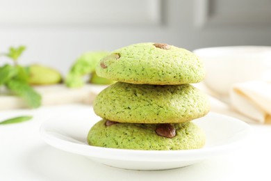 Photo of Delicious mint chocolate chip cookies on white table, closeup