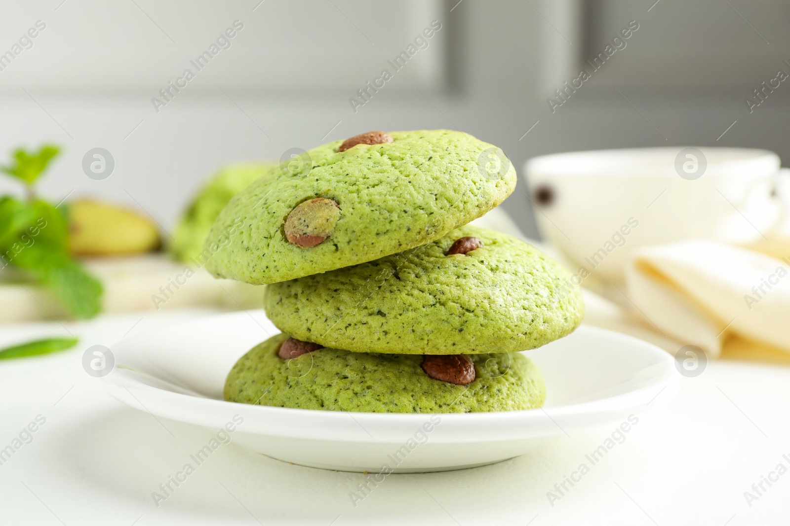 Photo of Delicious mint chocolate chip cookies on white table, closeup