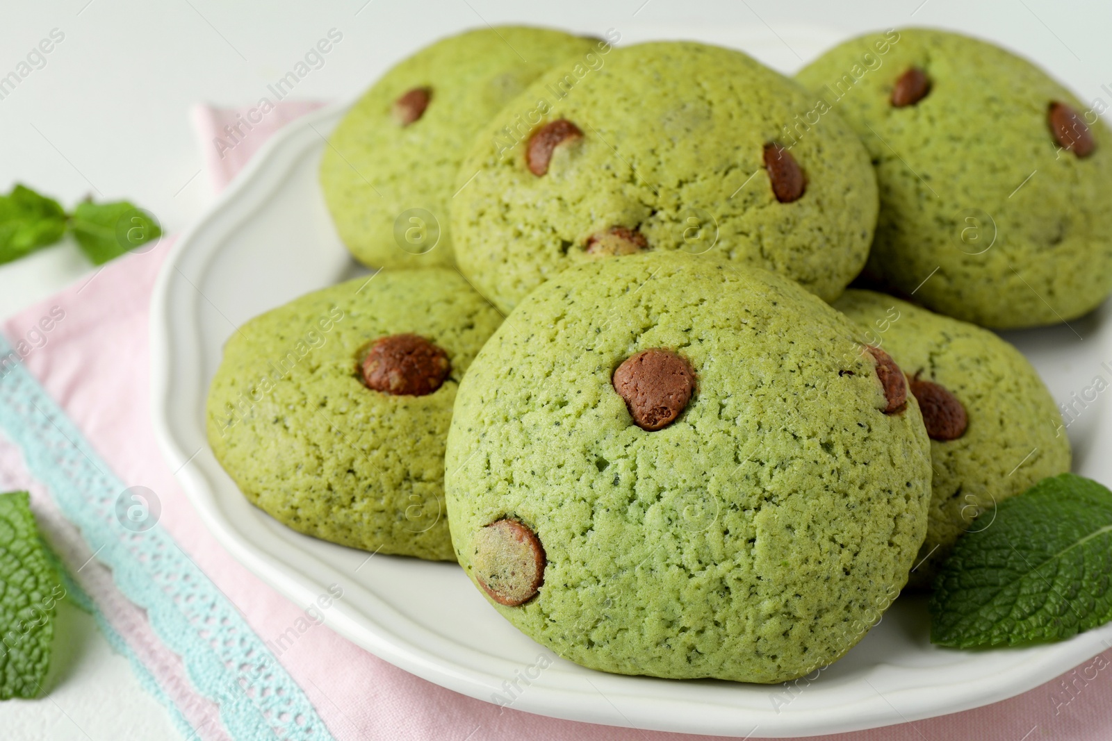 Photo of Delicious mint chocolate chip cookies on table, closeup