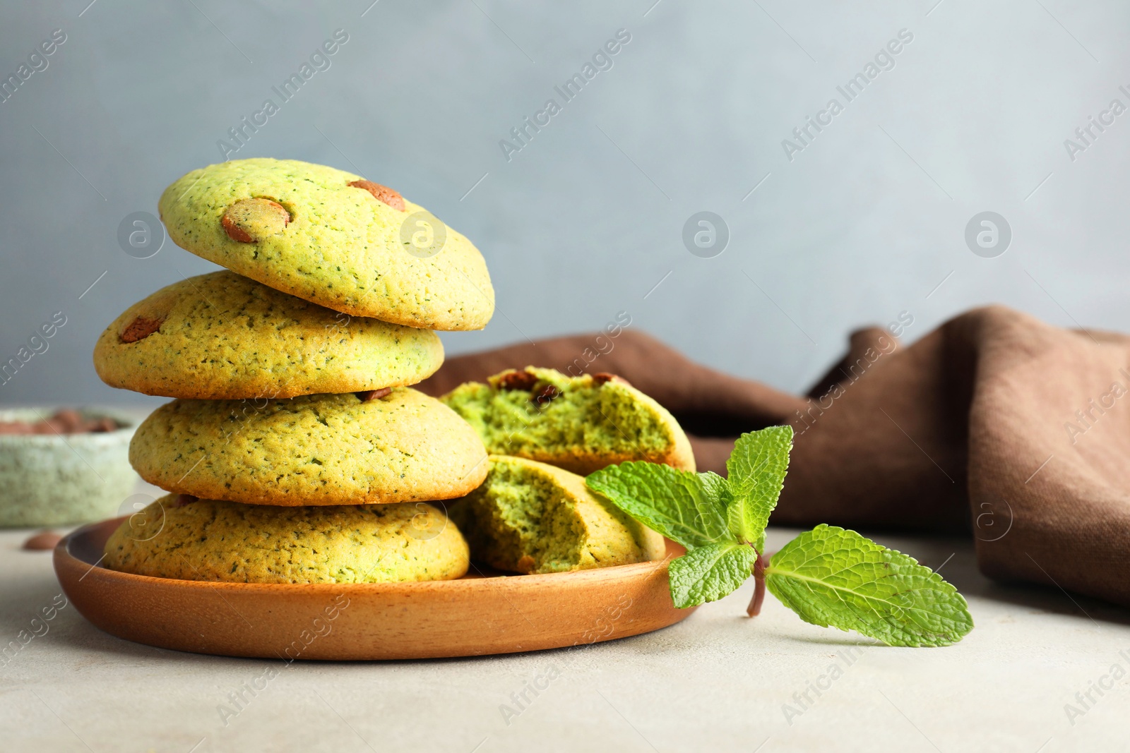 Photo of Delicious mint chocolate chip cookies on light table, closeup