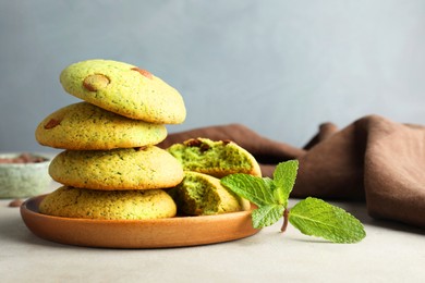 Photo of Delicious mint chocolate chip cookies on light table, closeup