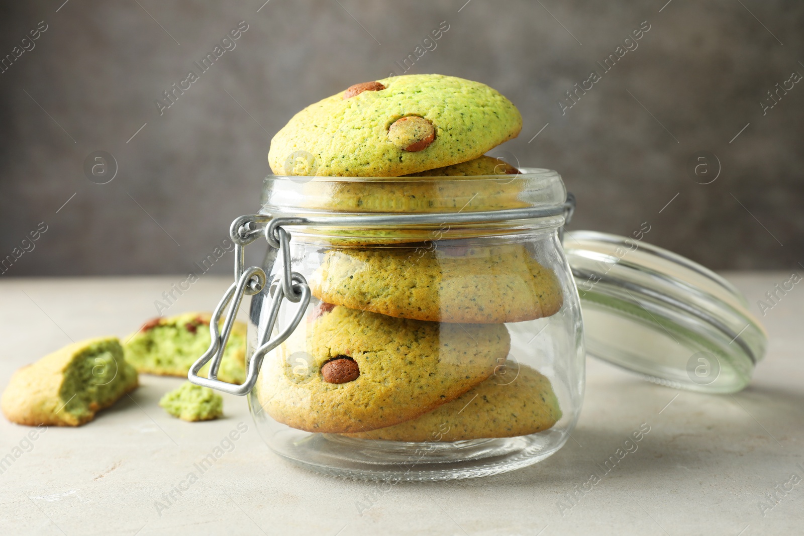 Photo of Delicious mint chocolate chip cookies in jar on light table, closeup