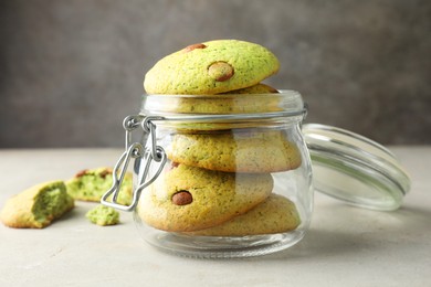 Photo of Delicious mint chocolate chip cookies in jar on light table, closeup