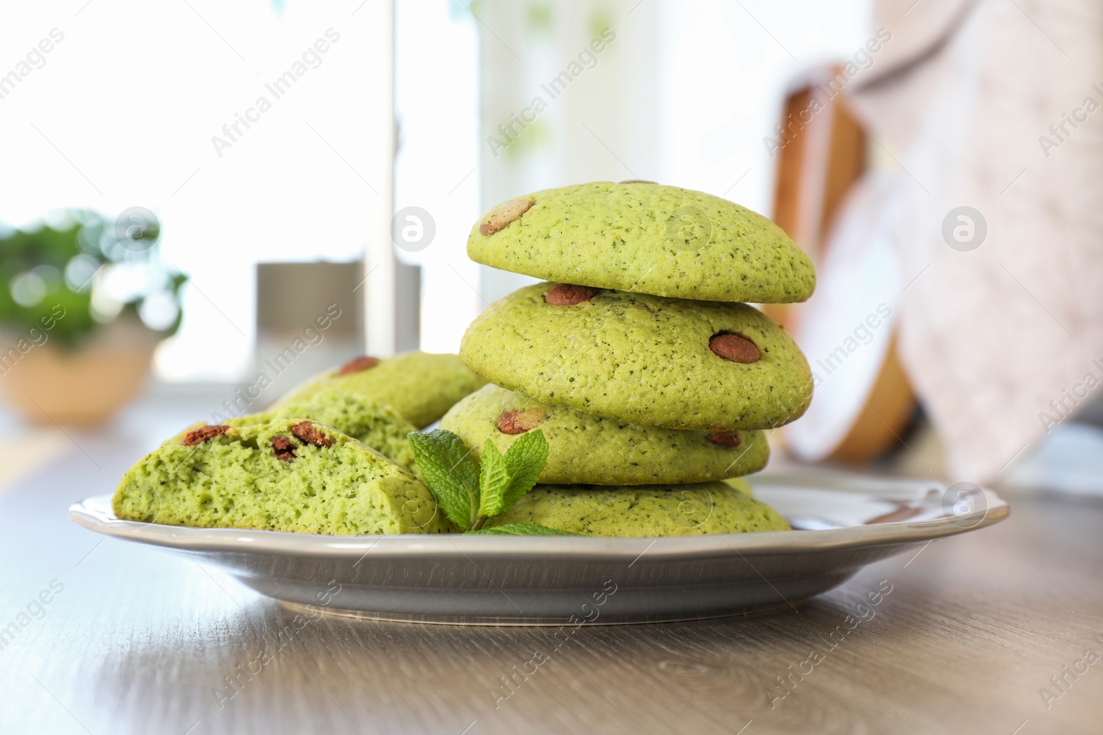 Photo of Delicious mint chocolate chip cookies on wooden table