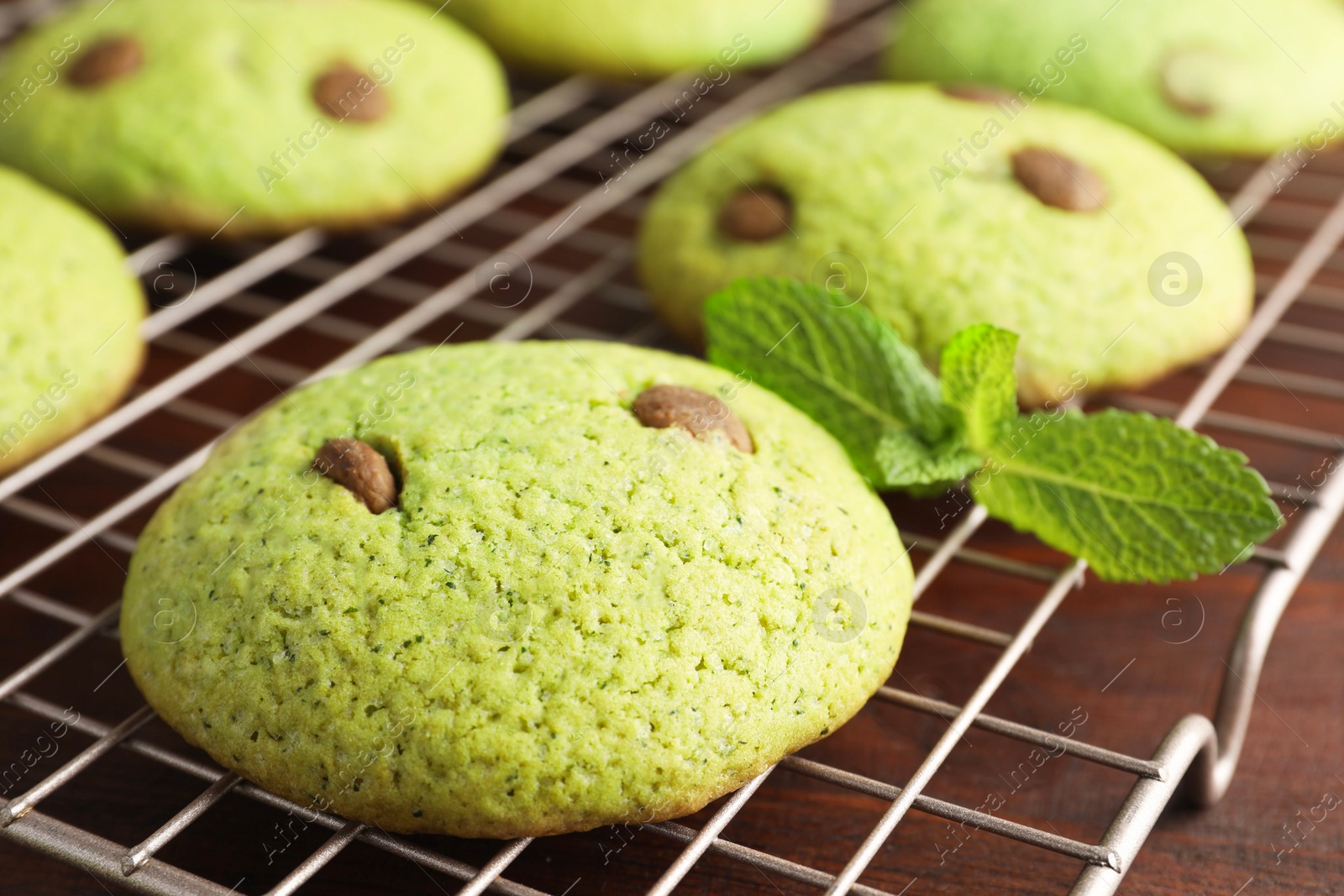 Photo of Delicious mint chocolate chip cookies on wooden table, closeup