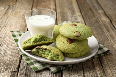 Photo of Delicious mint chocolate chip cookies and milk on wooden table