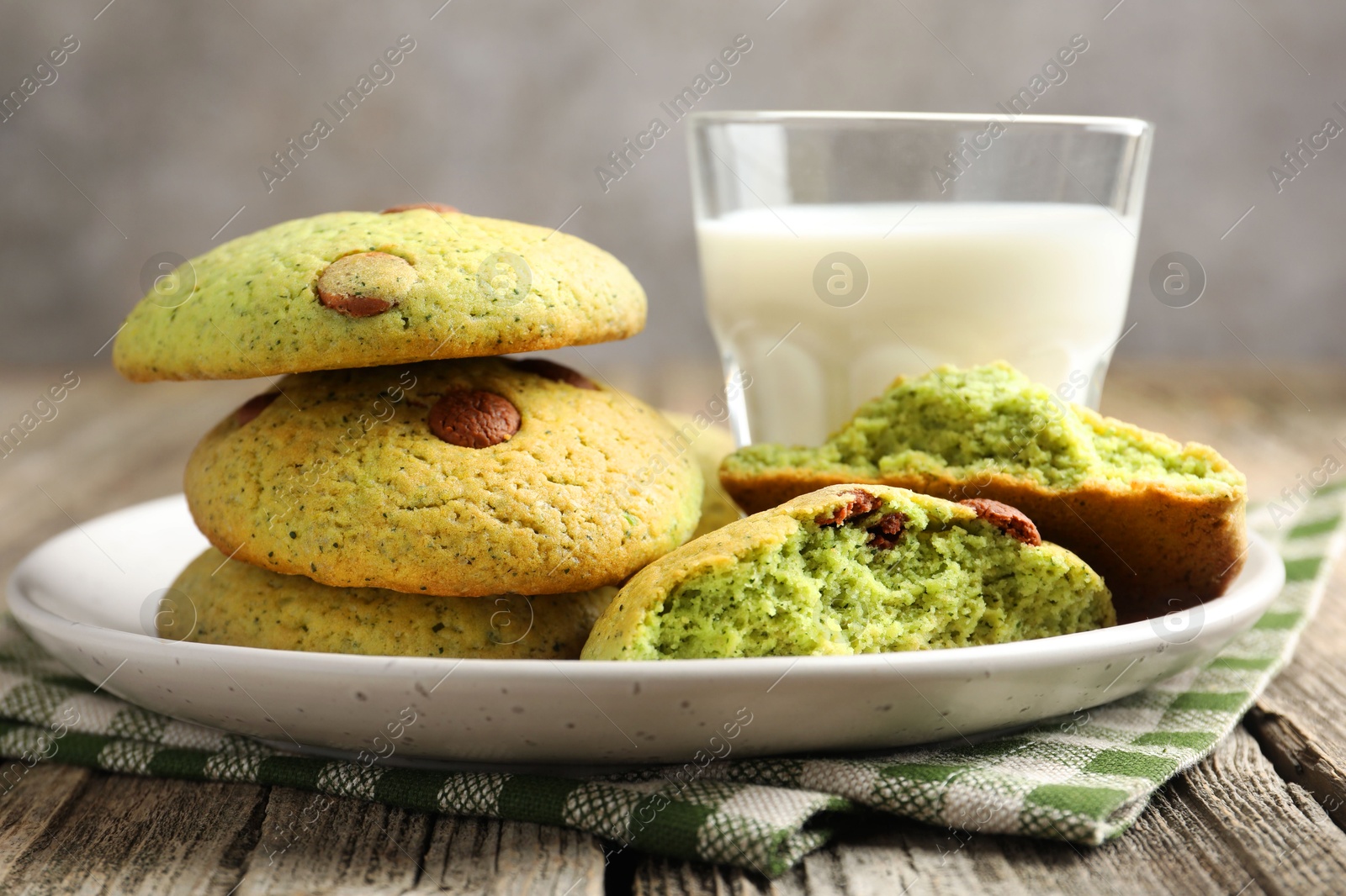 Photo of Delicious mint chocolate chip cookies and milk on wooden table, closeup