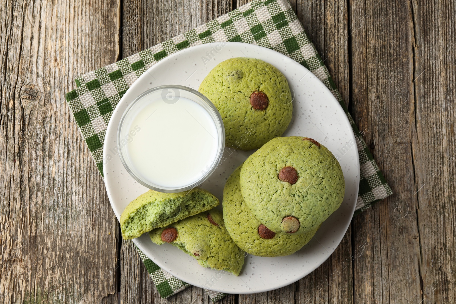 Photo of Delicious mint chocolate chip cookies and milk on wooden table, top view