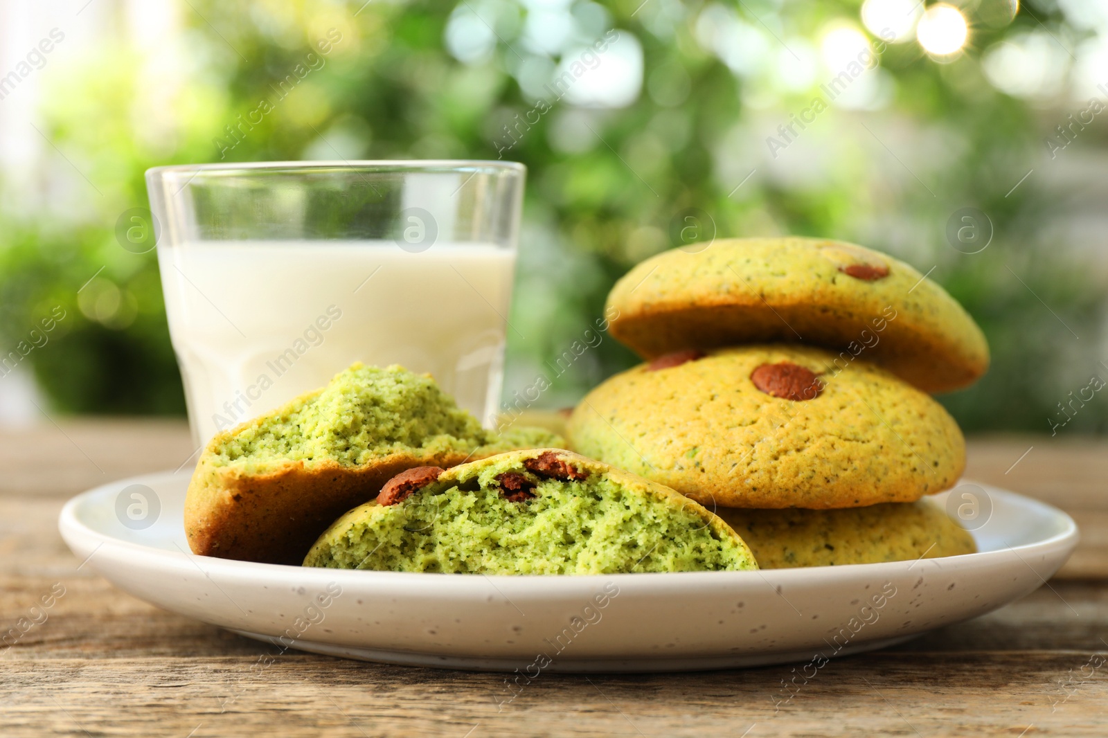 Photo of Delicious mint chocolate chip cookies and milk on wooden table