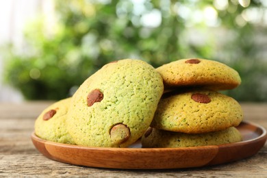 Photo of Delicious mint chocolate chip cookies on wooden table, closeup