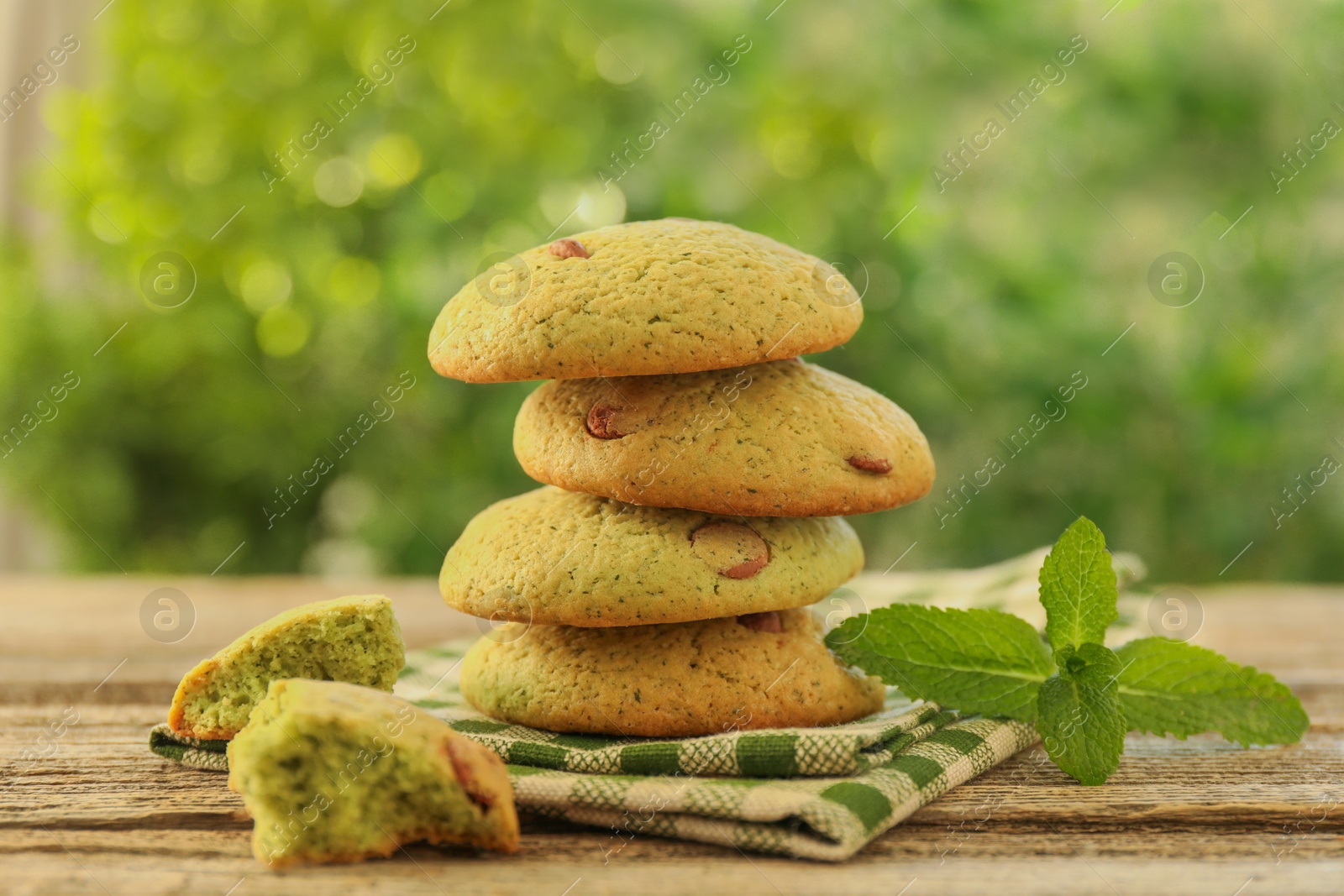 Photo of Delicious mint chocolate chip cookies on wooden table, closeup