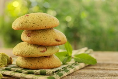 Photo of Delicious mint chocolate chip cookies on wooden table, closeup. Space for text