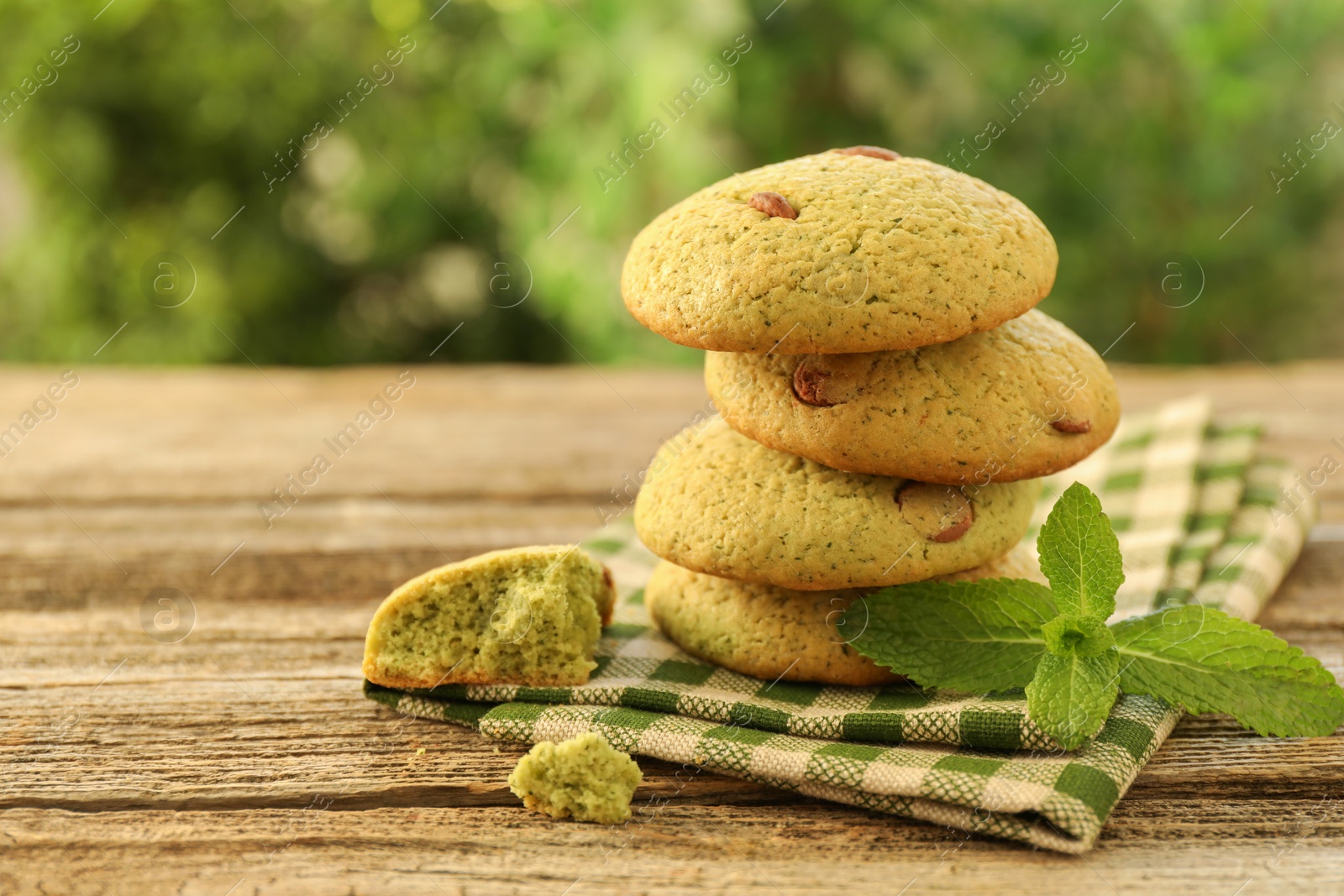 Photo of Delicious mint chocolate chip cookies on wooden table, closeup. Space for text