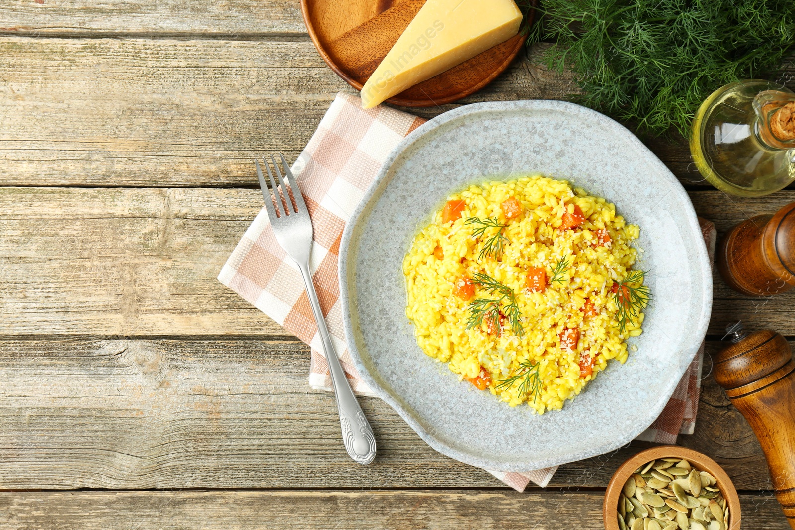 Photo of Delicious pumpkin risotto served on wooden table, flat lay. Space for text