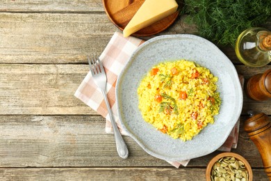 Photo of Delicious pumpkin risotto served on wooden table, flat lay. Space for text