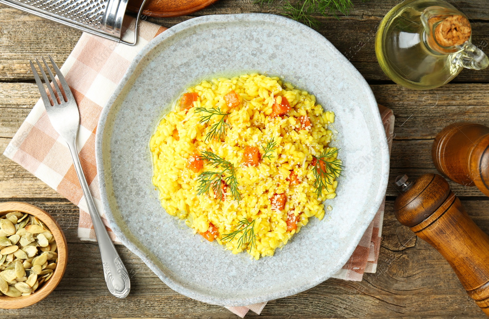 Photo of Delicious pumpkin risotto served on wooden table, flat lay