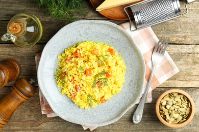 Photo of Delicious pumpkin risotto served on wooden table, flat lay