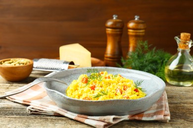 Photo of Delicious pumpkin risotto served on wooden table