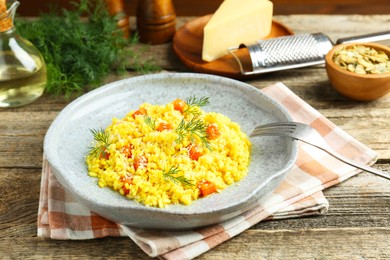 Photo of Delicious pumpkin risotto served on wooden table, closeup