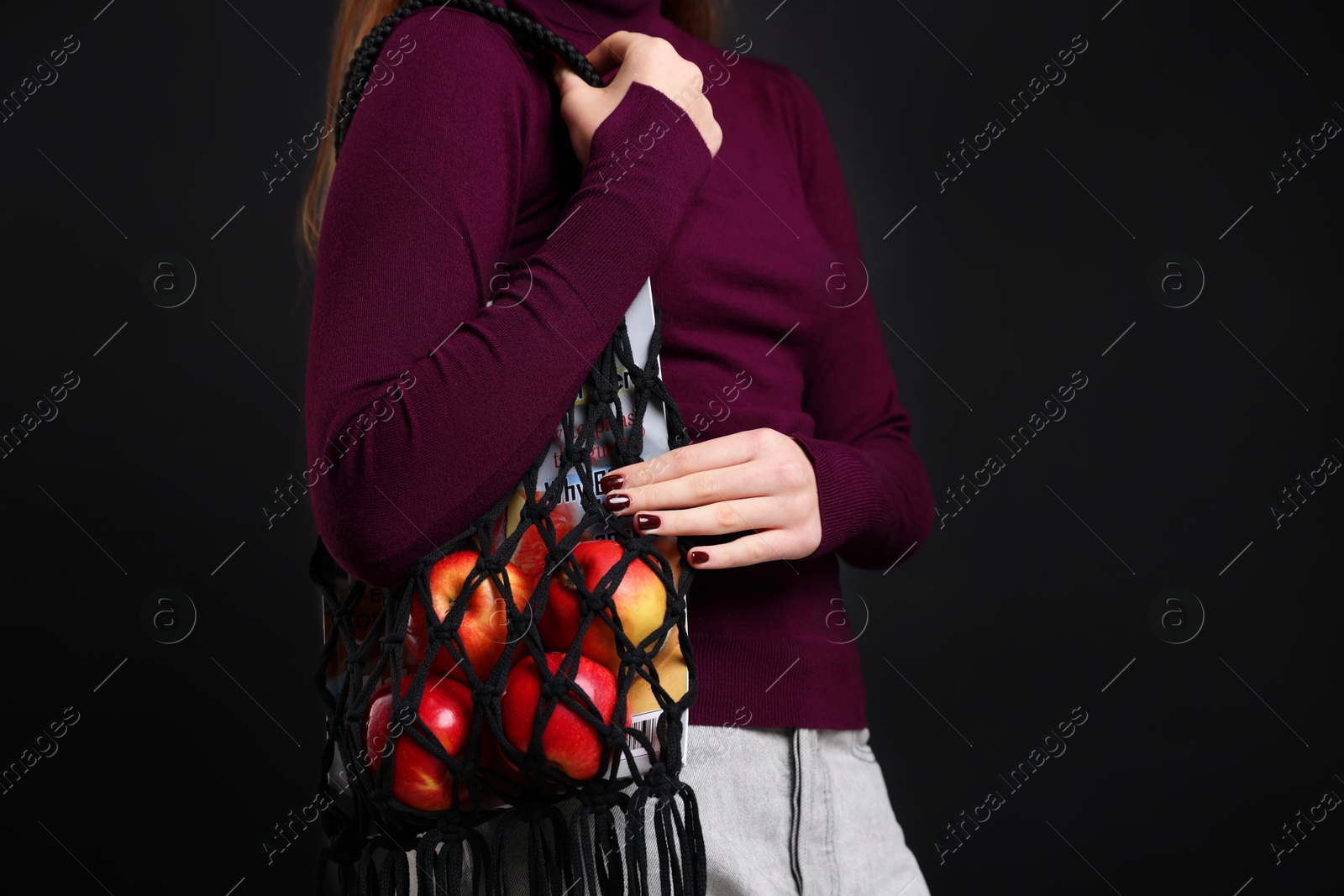 Photo of Teenage girl with handmade macrame bag on black background, closeup