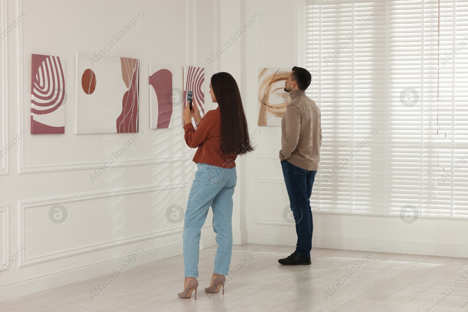 Photo of Woman taking photo of painting in art gallery